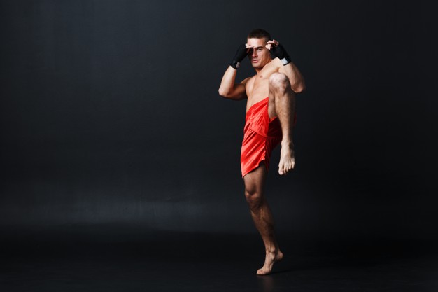 sportsman-muay-thai-man-boxer-stance-ad-knee-kick-black-background_183314-1607