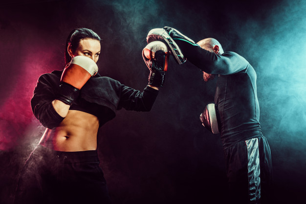 woman-exercising-with-trainer-boxing-self-defense-lesson_136403-7575